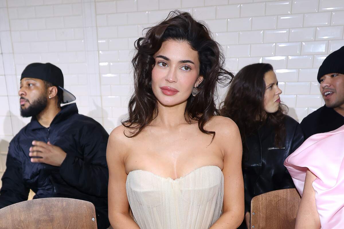 Makeup mogul Kylie Jenner wears a white gown and sits in her seat at the Jean Paul Gaultier Haute Couture Spring/Summer 2024