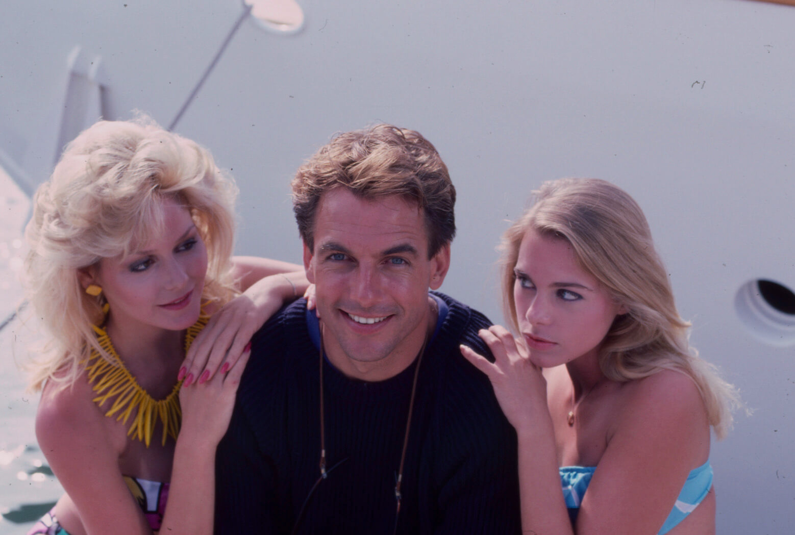 Mark Harmon in 1986 next to two women who are holding his shoulders in the ABC TV movie, 'Prince Of Bel Air'