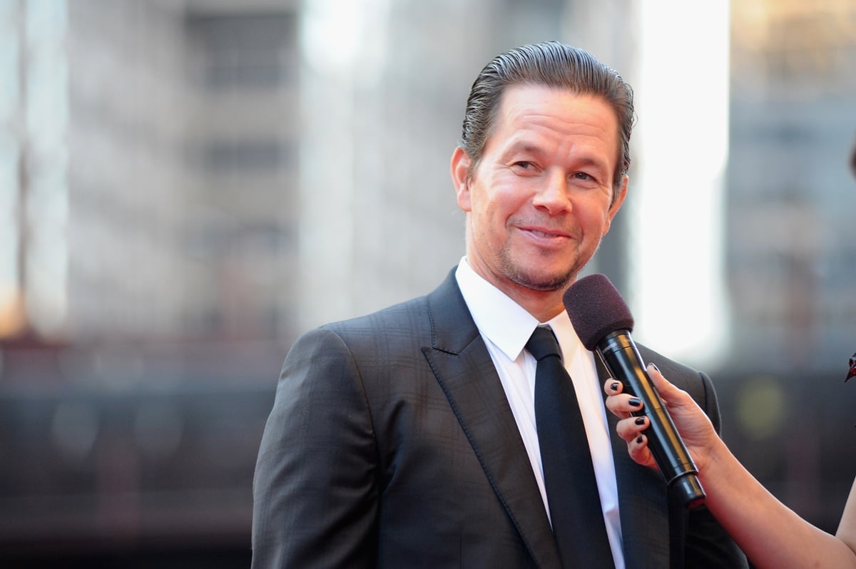 Mark Wahlberg smiling in a suit at the 'Transformers: The Last Knight' premiere.