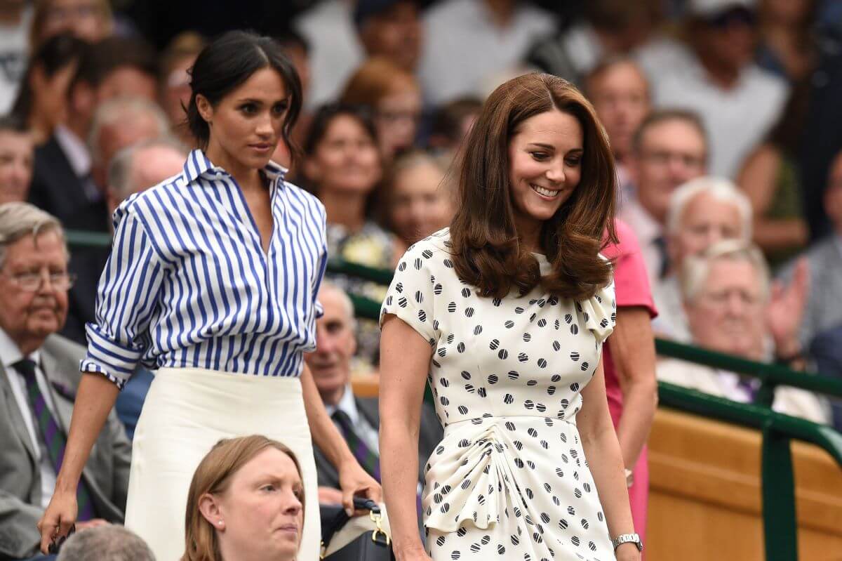 Meghan Markle and Kate Middleton take their seats in the Royal box on Centre Court at Wimbledon