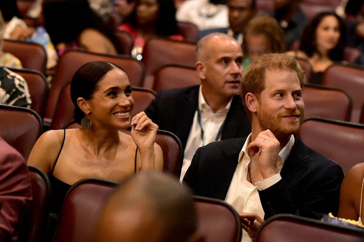 Meghan Markle and Prince Harry sit in a theater at the Jamaica premiere of 'Bob Marley One Love'