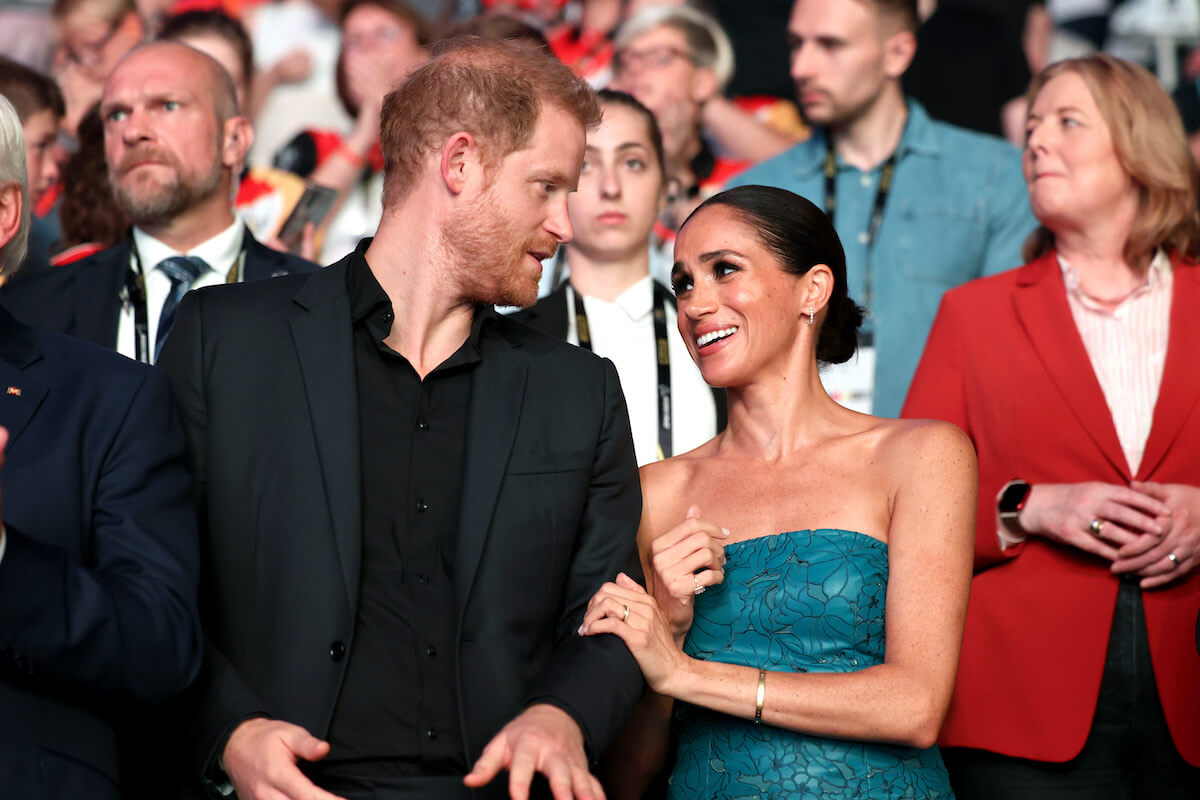 Prince Harry and Meghan Markle, who were the subject of a joke in Jo Koy's opening monologue at the Golden Globes, stand next to each other
