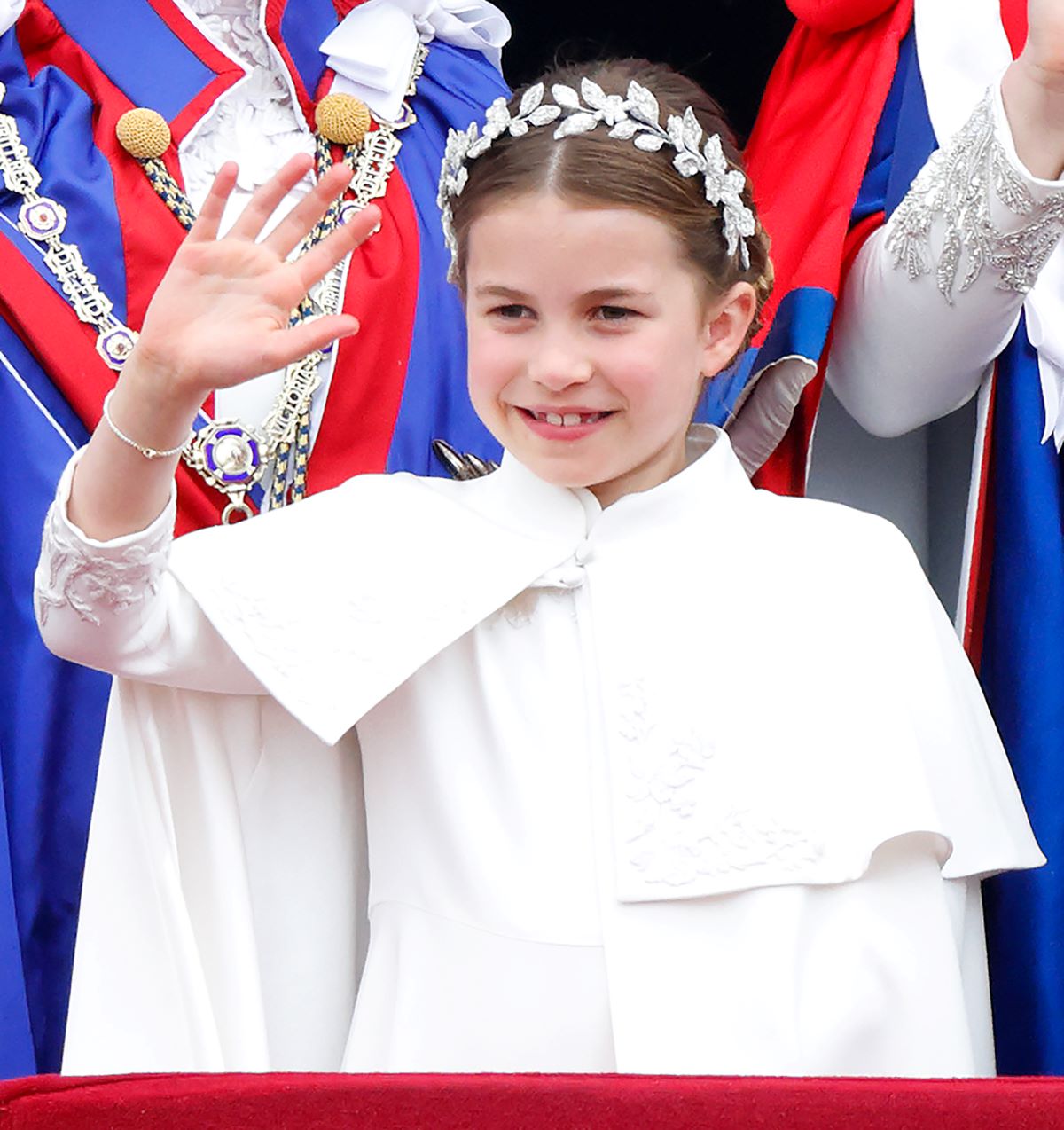 Princess Charlotte smiles and waves from the balcony of Buckingham Palace following the coronation of King Charles III