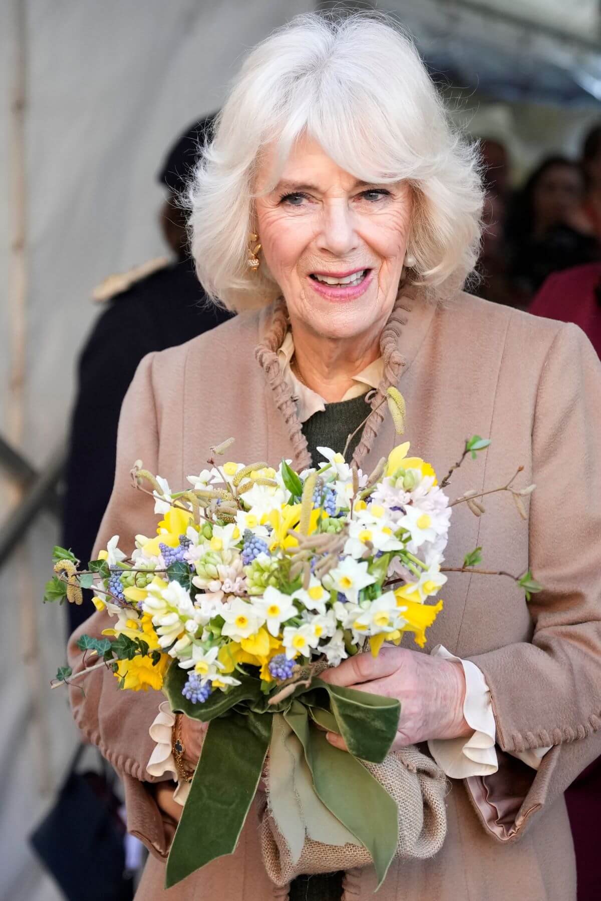 Queen Camilla holding a bouquet following her visit to a women's refuge Swindon, England
