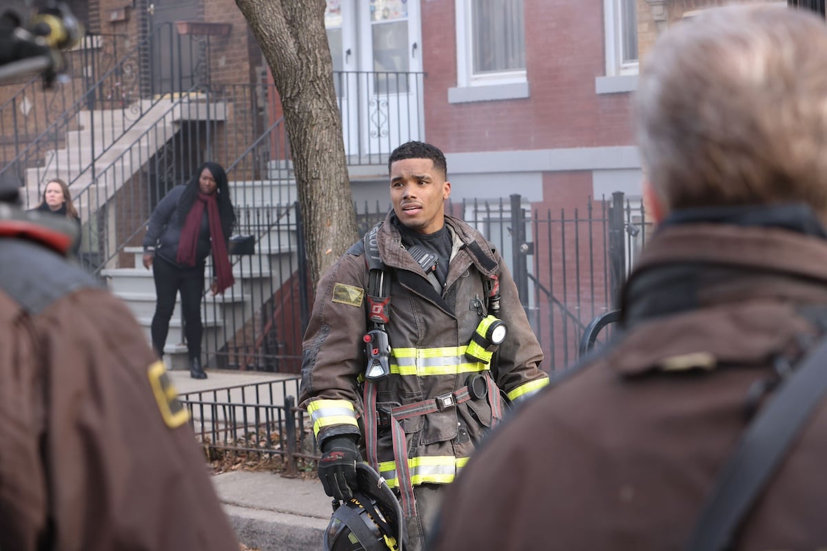 Rome Flynn standing outside a house in firefighter gear in 'Chicago Fire'
