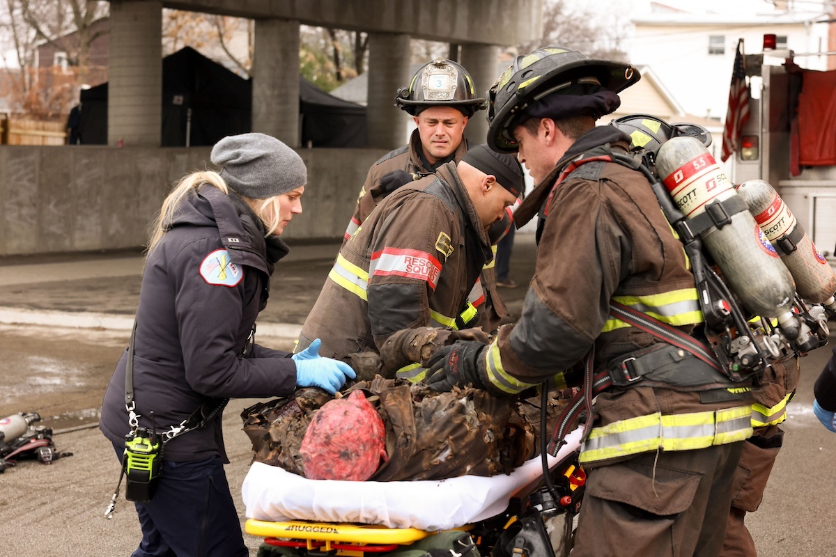 Sylvie Brett and Kelly Severide helping a burned man on a stretcher in the 'Chicago Fire' Season 12 premiere