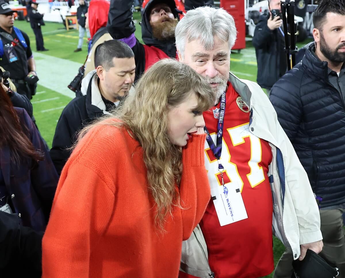 Taylor Swift is seen on the field talking to Travis Kelce's father, Ed Kelce, after Kansas City Chiefs AFC Championship Game
