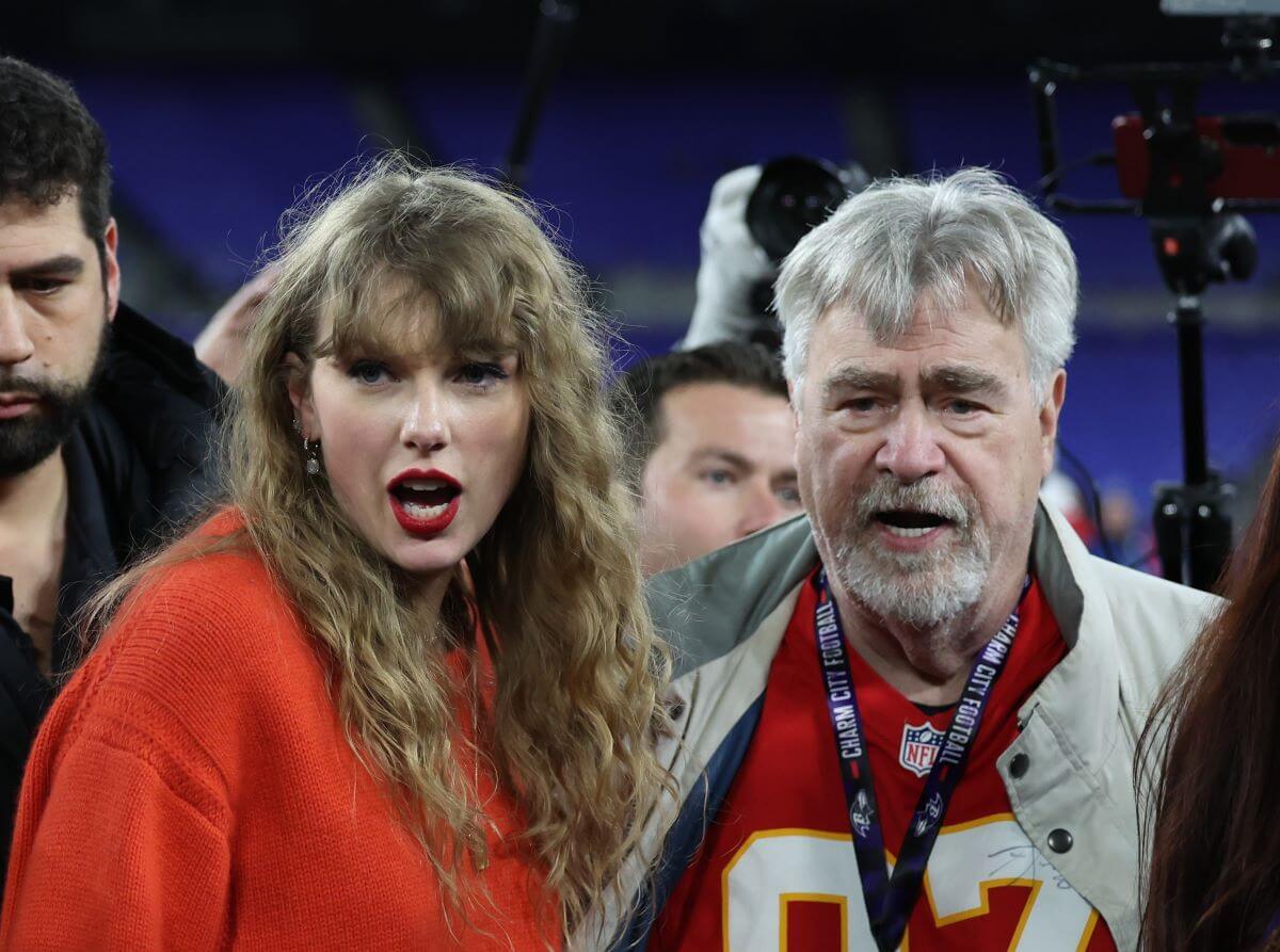 Taylor Swift on the field with Travis Kelce's father, Ed Kelce, after a game between the Baltimore Ravens and the Kansas City Chiefs