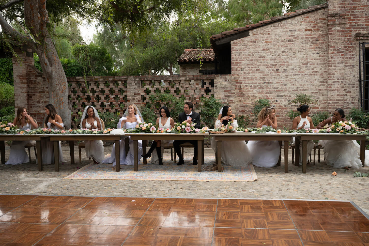 'The Bachelor' Season 28 Episode 2 group date with Joey Graziadei sitting at a table and contestants sitting at the table in wedding dresses