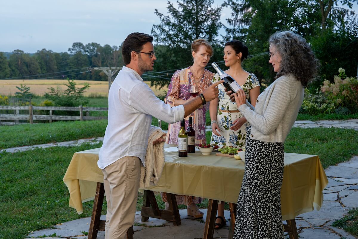 Group of people toasting around an outdoor table in 'The Way Home' Season 2