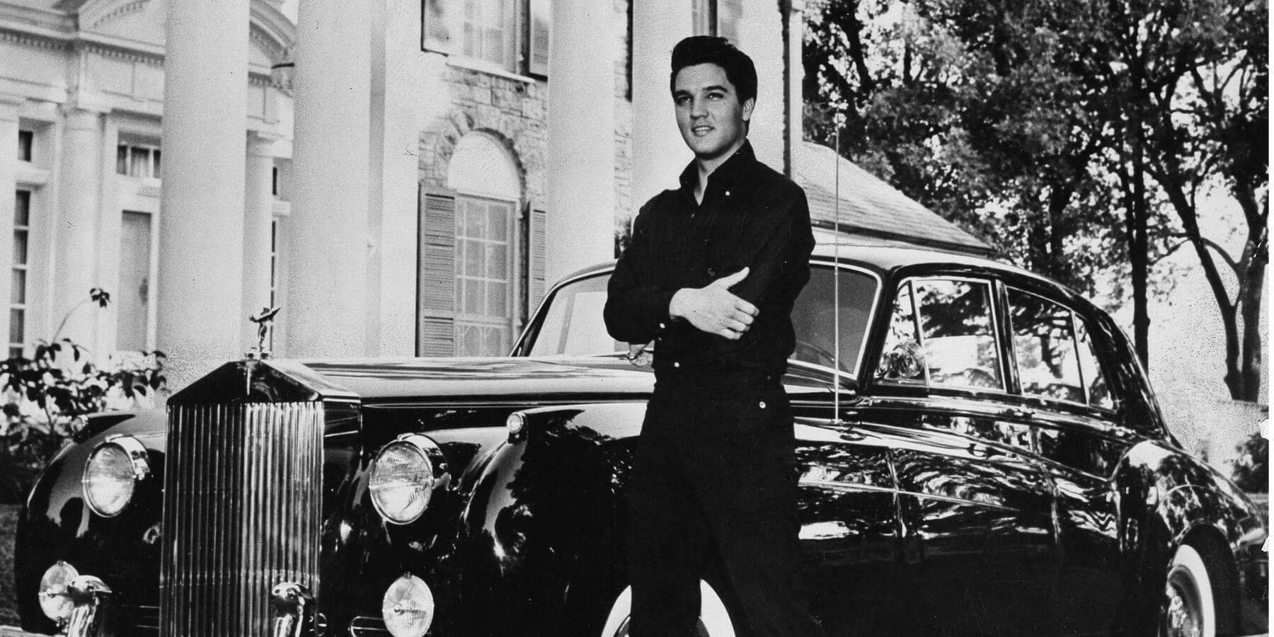Elvis Presley poses outside of his Graceland home