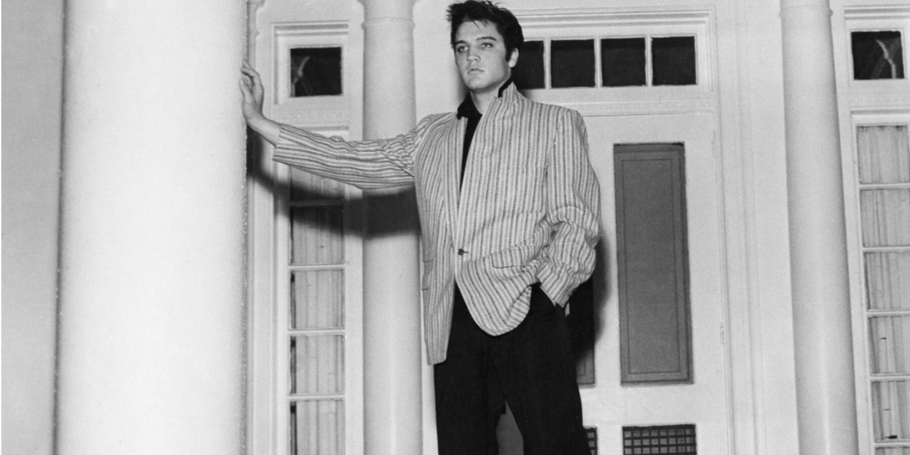 Elvis Presley leans on a column outside of his Graceland home