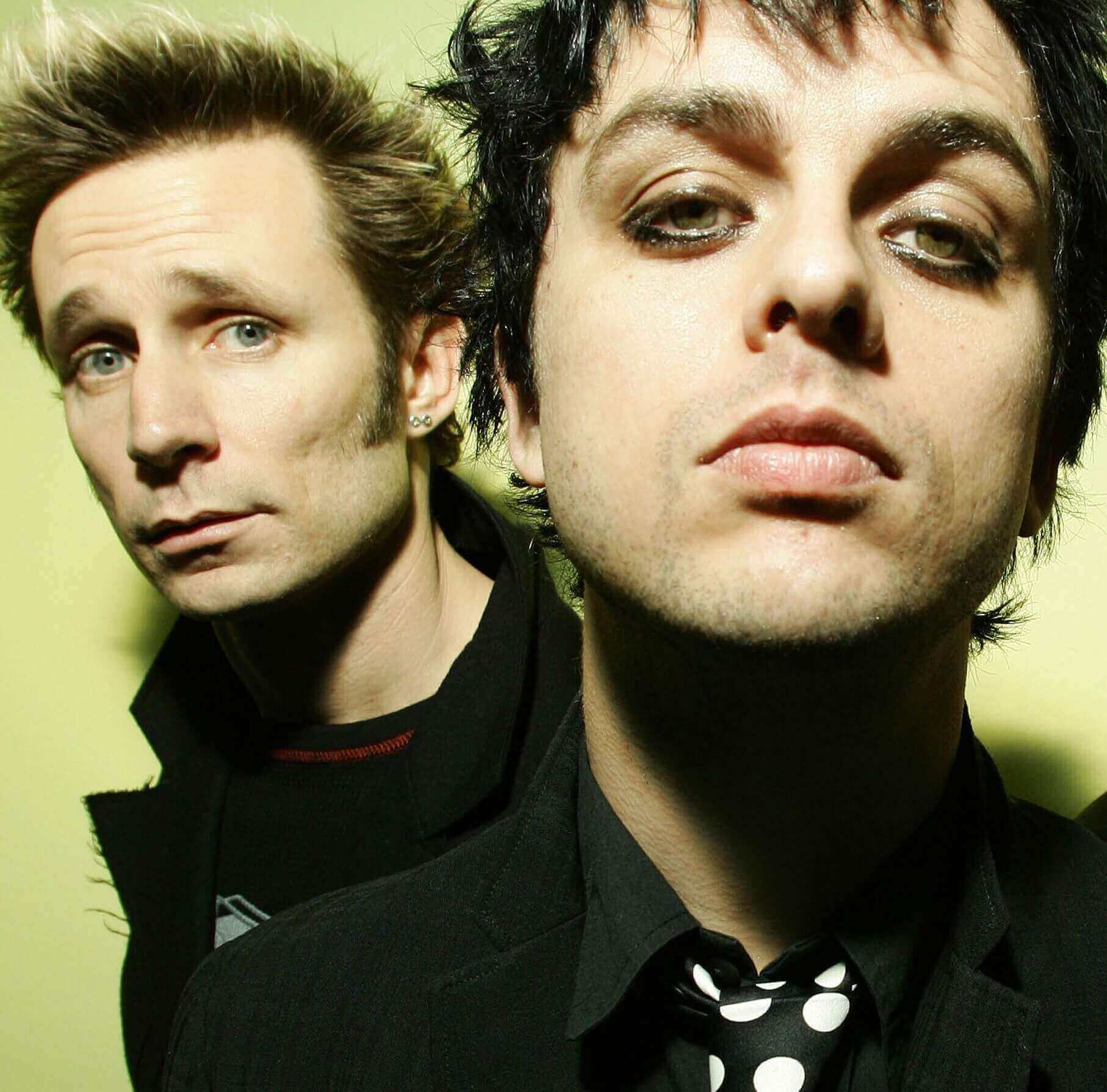 Green Day's Mike Dirnt and Billie Joe Armstrong with a green backdrop