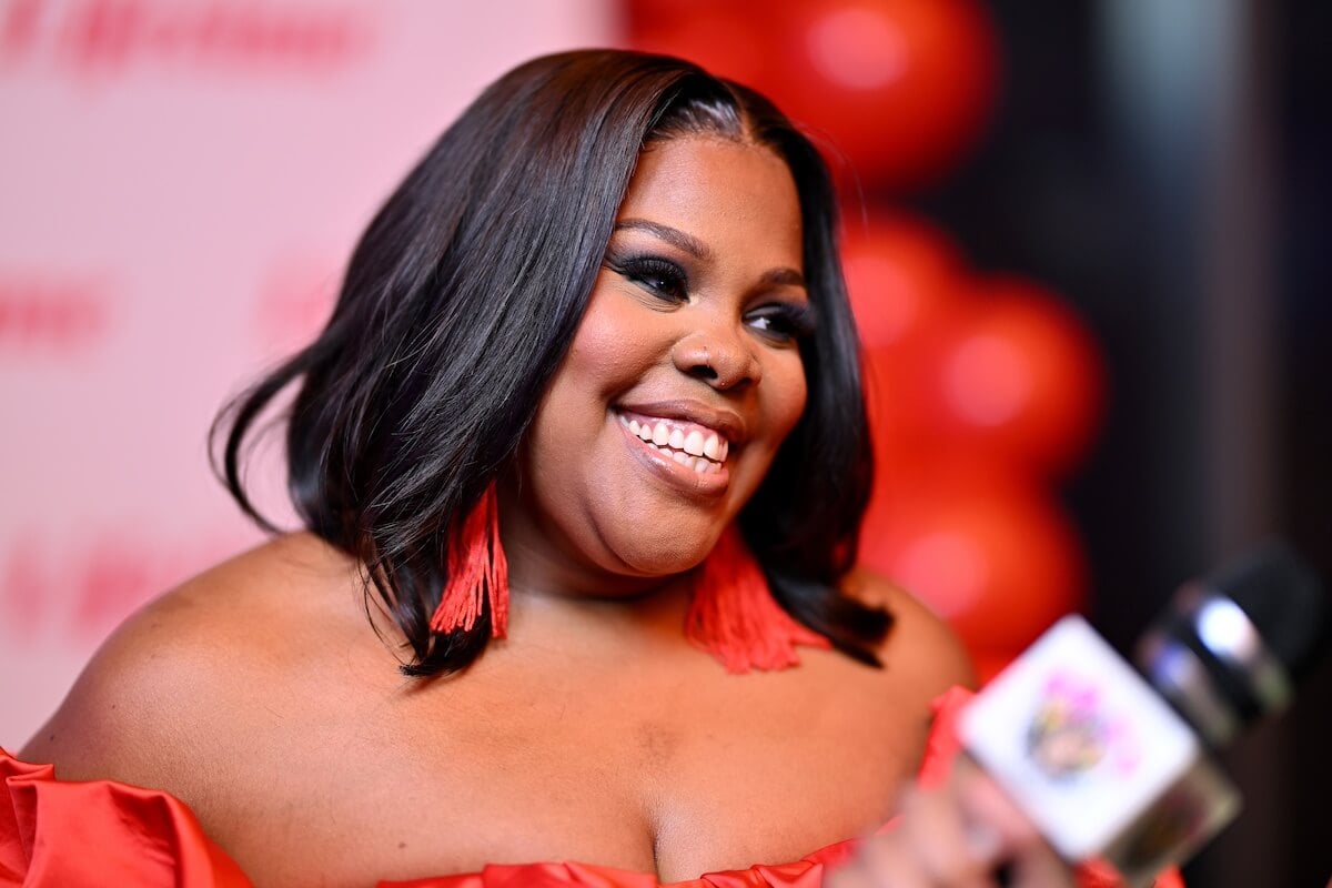 Smiling Amber Goodwin in an off-the-shoulder dress