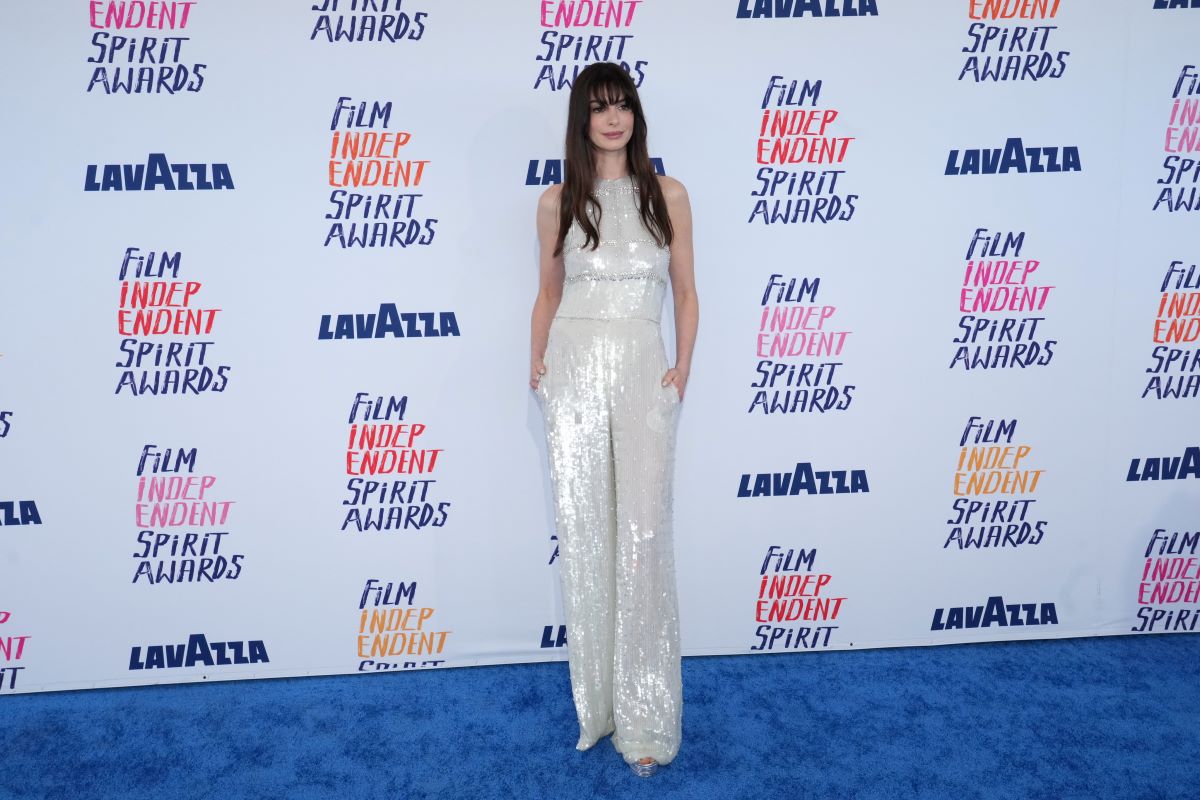 Anne Hathaway wears a silver jumpsuit on the carpet for the Independent Spirit Awards.