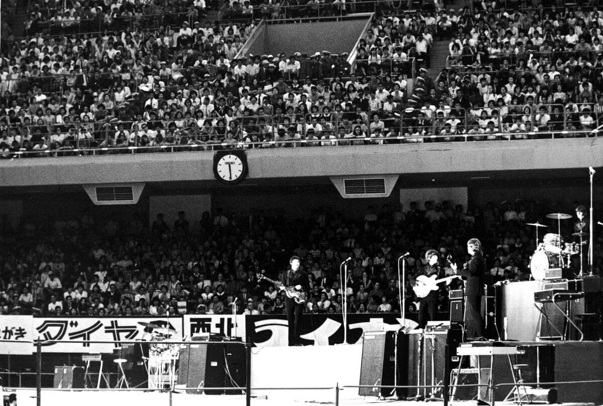 A black and white picture of The Beatles performing in Japan.