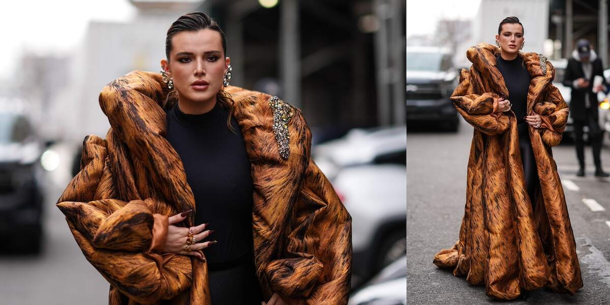 Actor Bella Thorne wears a brown oversized pleated gathered bejewelled / embellished / rhinestones long and large puffer coat , a black top, jewelry / earrings, rings, lipstick , make-up , outside Area, during New York Fashion Week