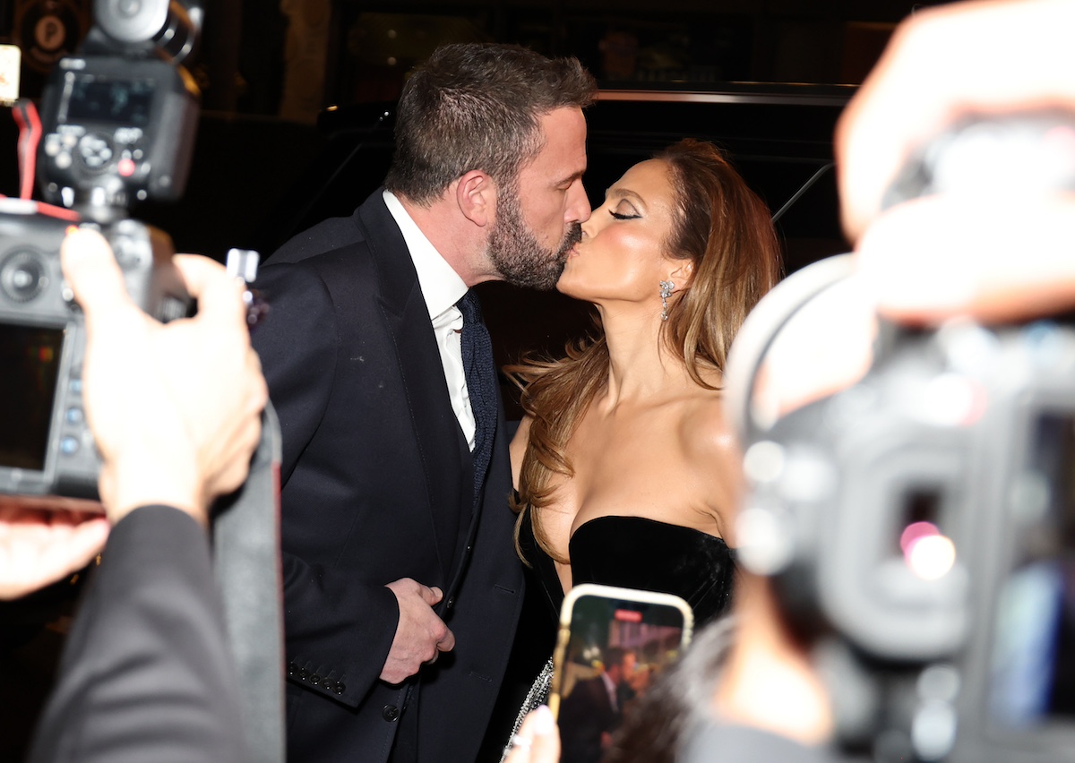 Ben Affleck and Jennifer Lopez kissing in front of photographers