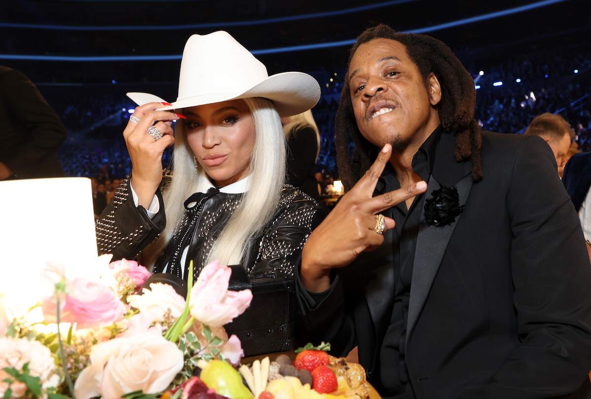 Married couple Beyoncé and Jay-Z wear formalwear and gesture to the camera at the 66th GRAMMY Awards