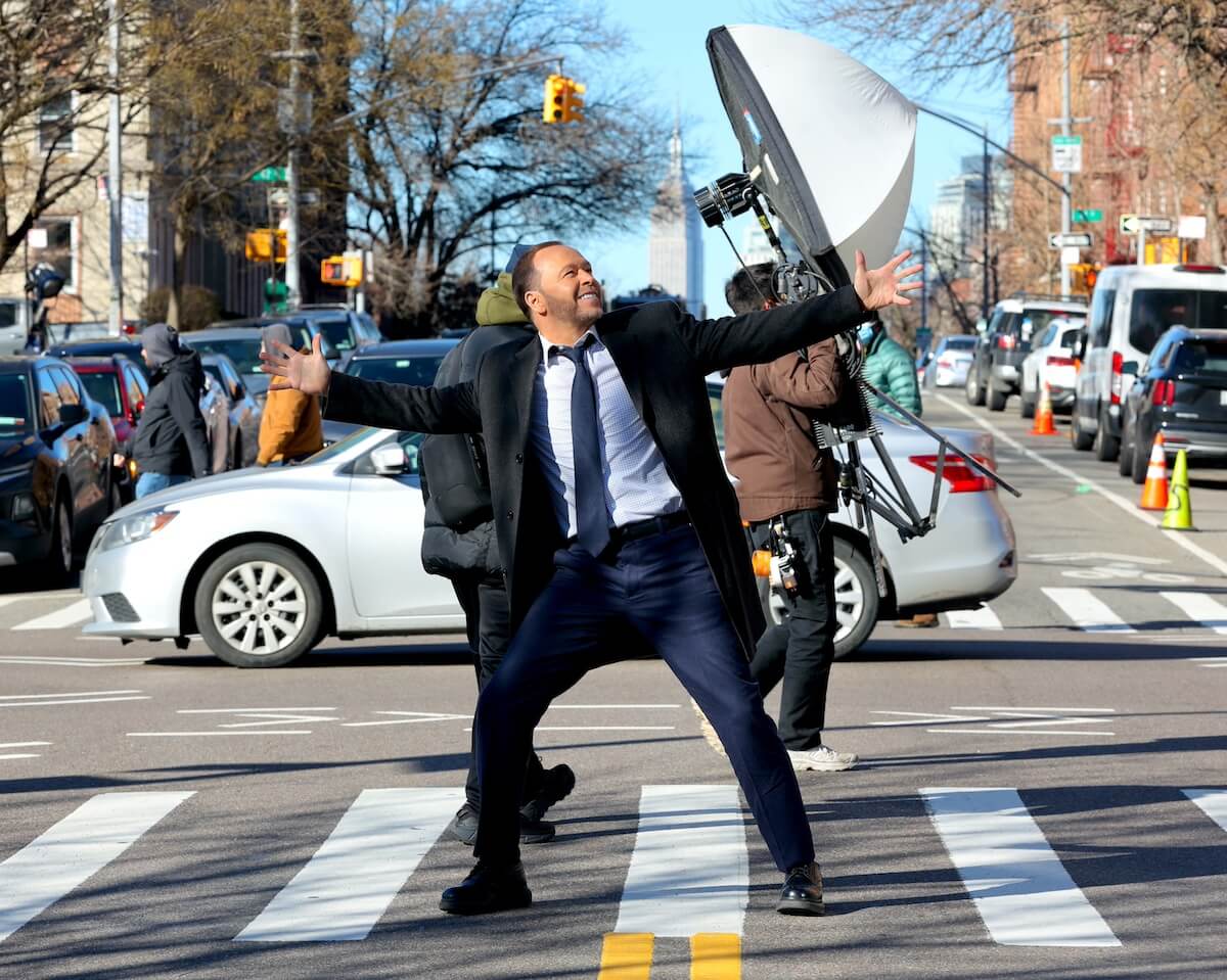 Donnie Wahlberg with his arms spread wide on an NYC street
