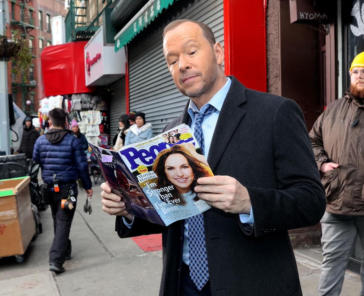 Donnie Wahlberg reading a copy of People Magazine with Mariska Hargitay on the cover