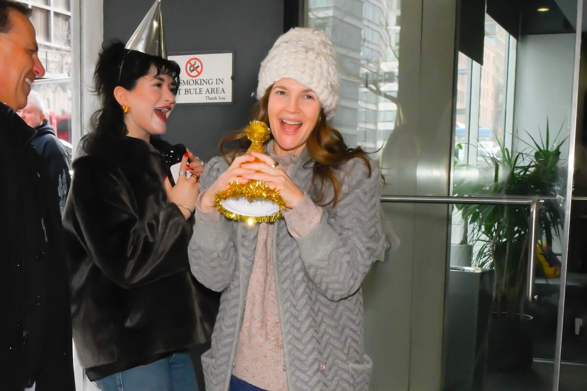Actor Drew Barrymore clutches her birthday hat and smiles for paparazzi on her birthday