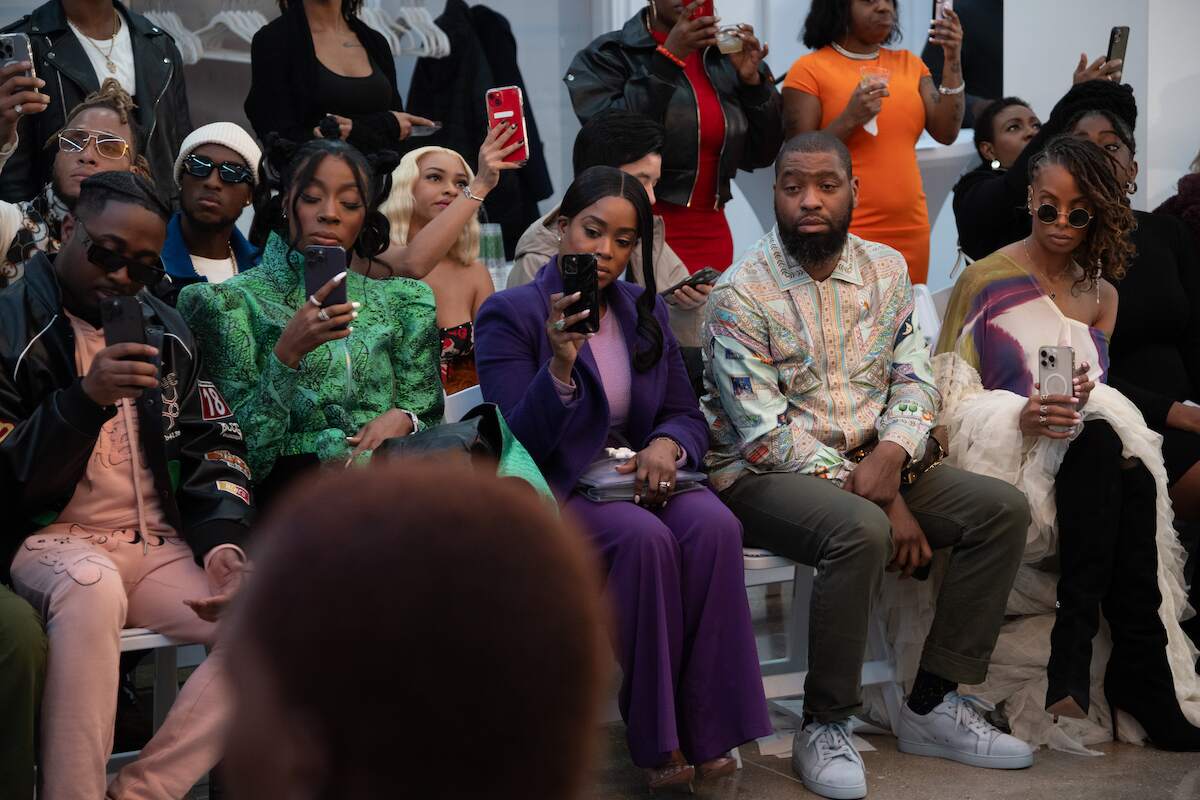 Eva Marcille takes a photo of a runway model at the Wavering Lines By Yutee Rone fashion show