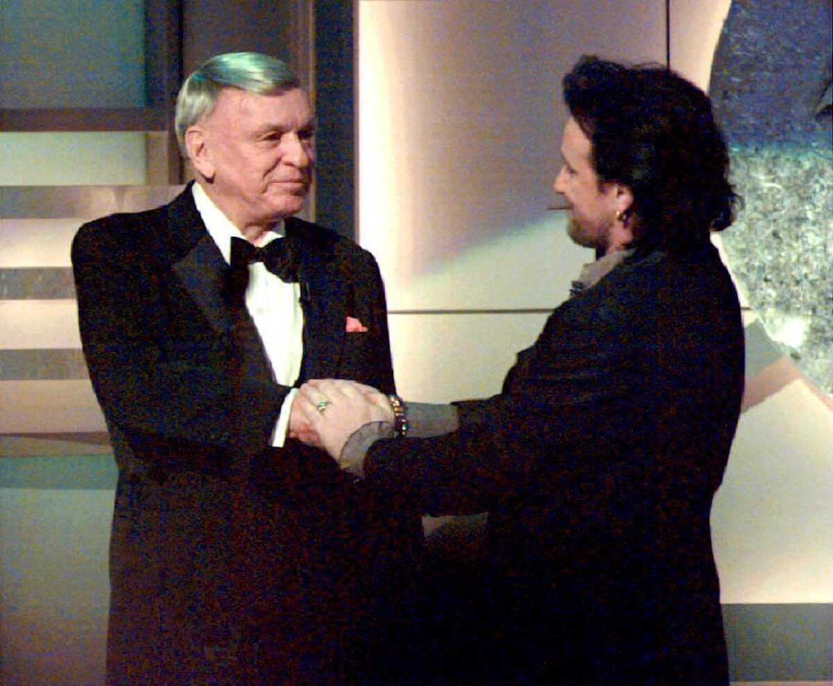 Bono shaking hands with Frank Sinatra at the Grammy Awards