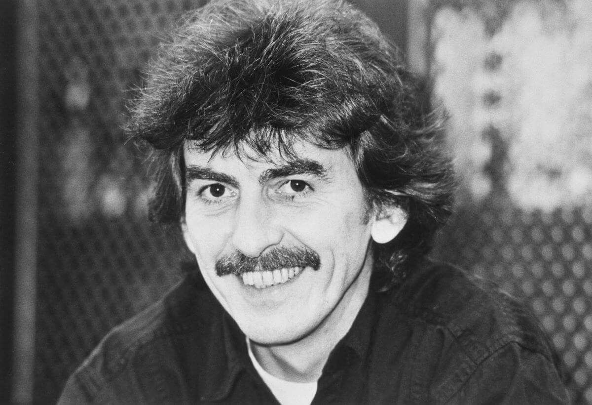 A black and white picture of George Harrison smiling.