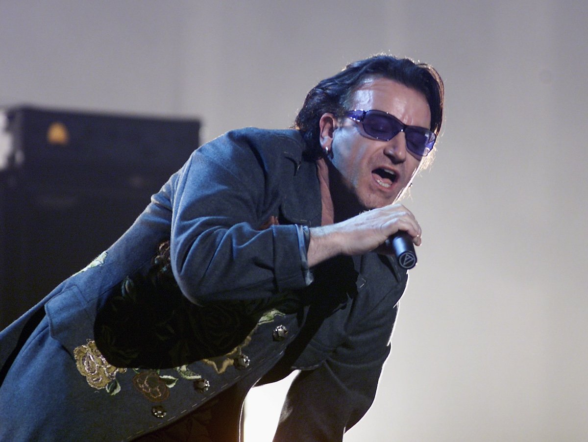 Bono holding a microphone and singing