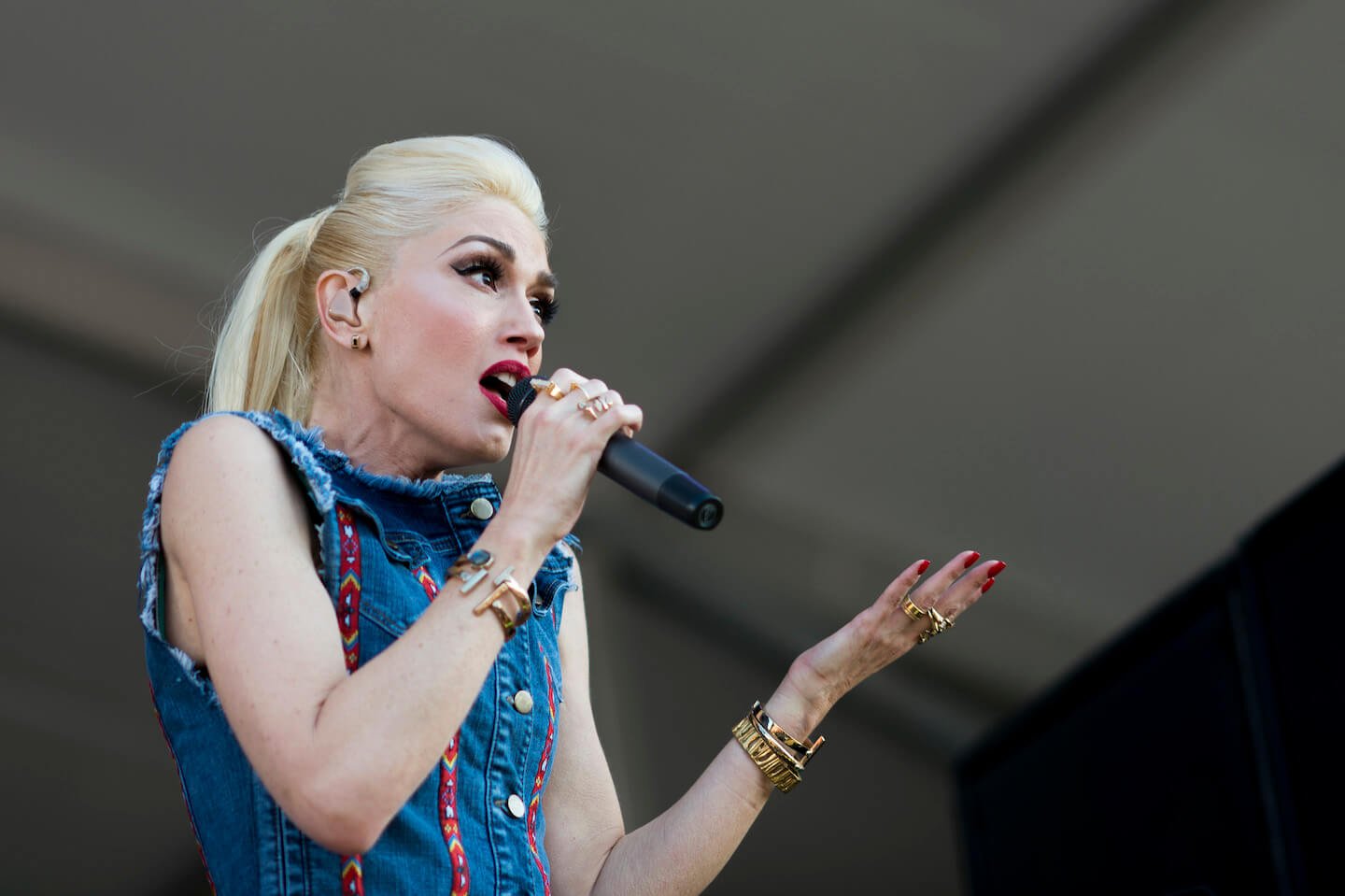 Gwen Stefani holding a microphone and singing on stage with No Doubt