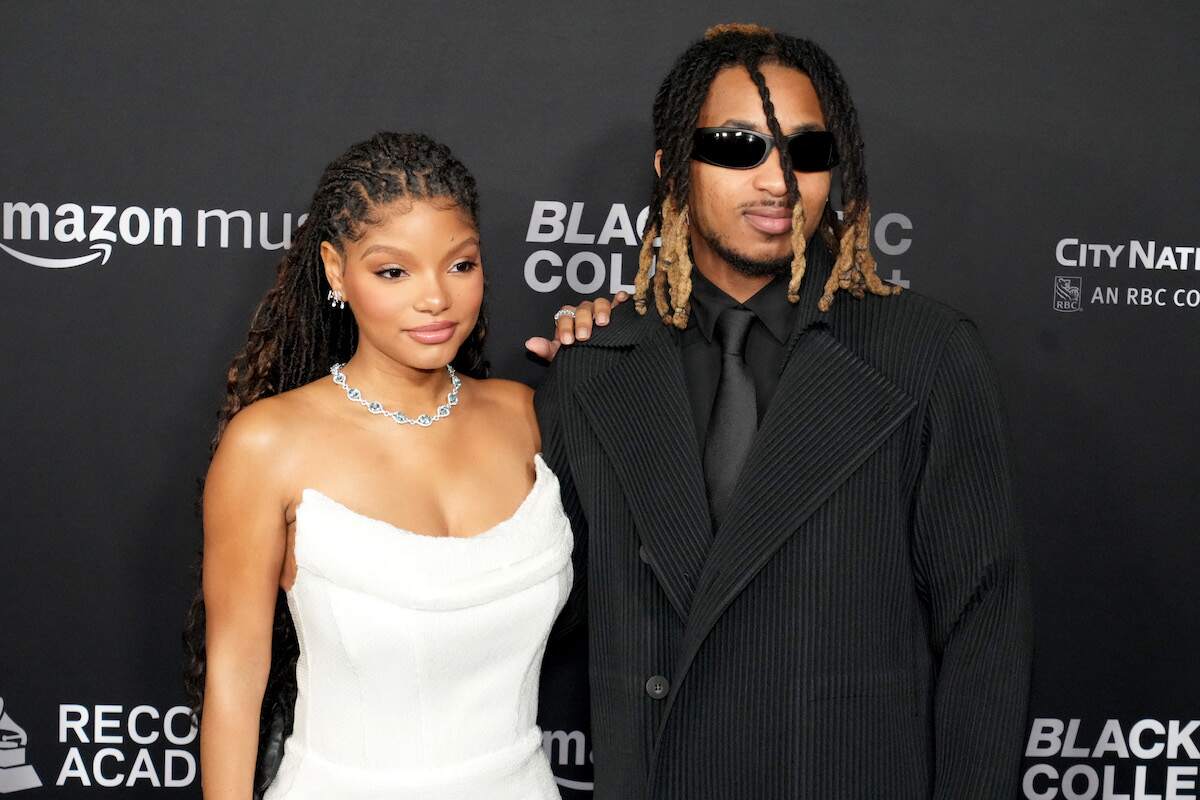 Wearing a white dress and black suit, Halle Bailey and DDG pose together