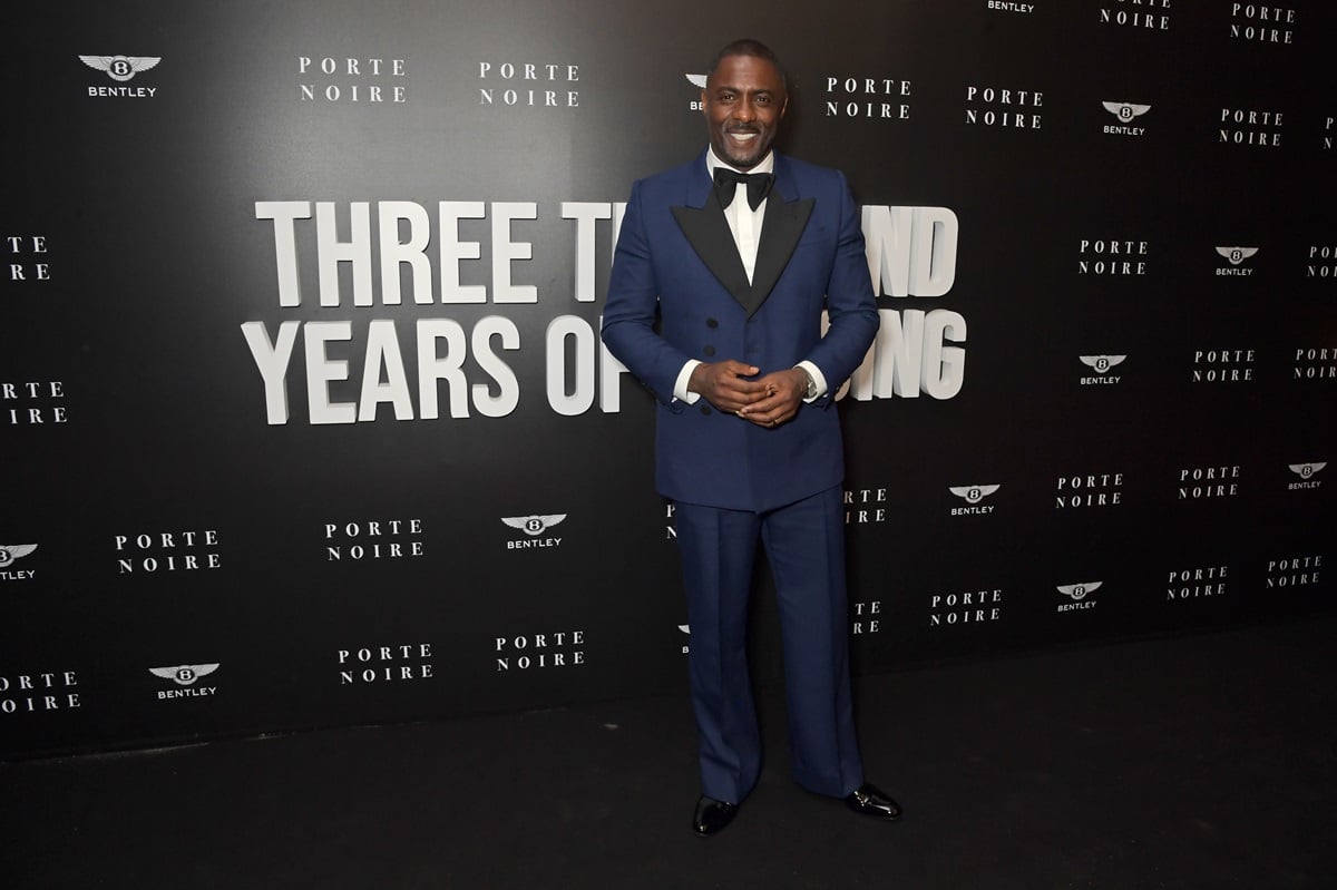Idris Elba posing in a blue bowtie suit at the Porte Noire, Chanel and Bentley "Three Thousand Years Of Longing" After Party.