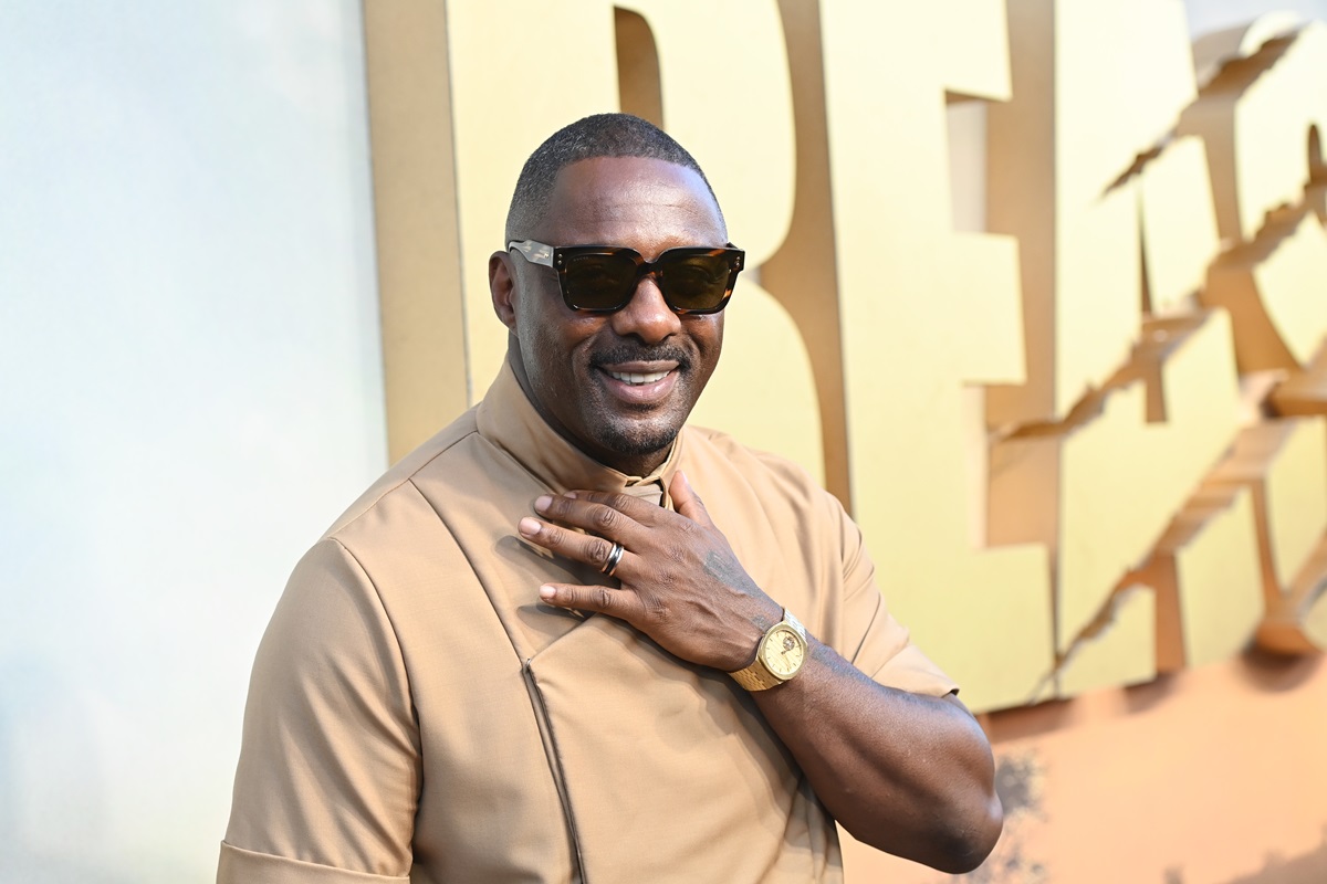 Idris Elba posing in a tan outfit at the premiere of 'Beast'.