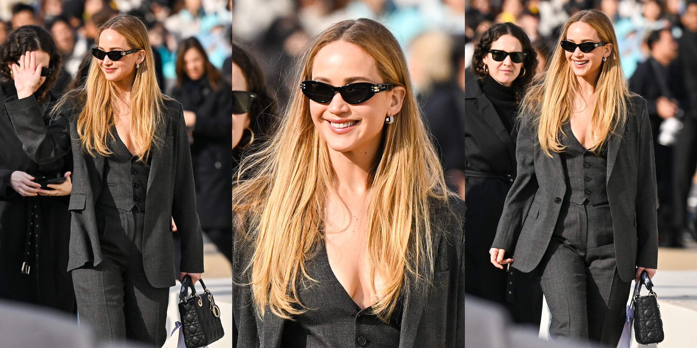 Actress Jennifer Lawrence waves to fans and wears a business-inspired black and gray outfit while walking to the Christian Dior fashion show in Paris, France