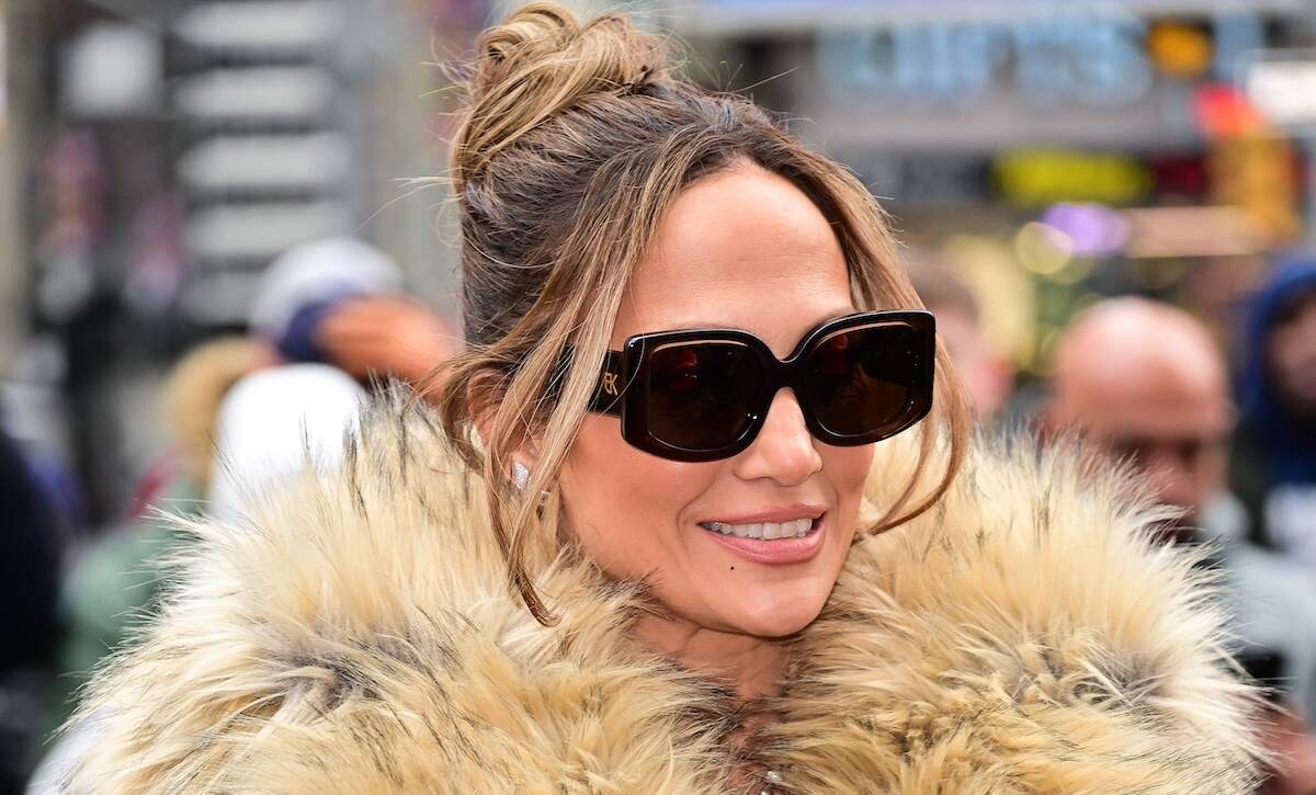 A closeup of singer/actor Jennifer Lopez wearing a tan fur coat and dark sunglasses