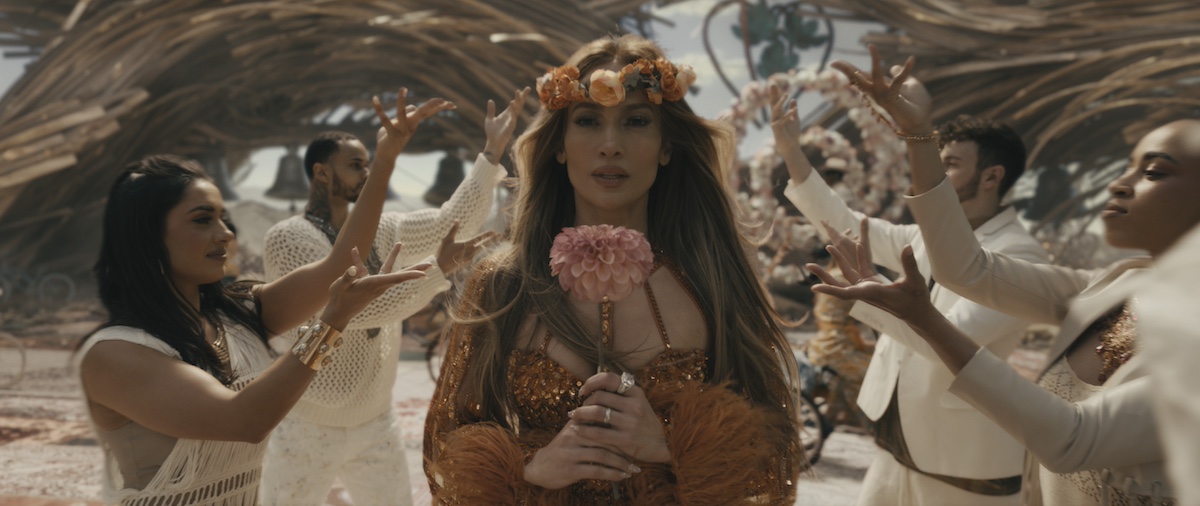 Jennifer Lopez wearing a flower crown and holding a flower in 'This Is Me ... Now: A Love Story'