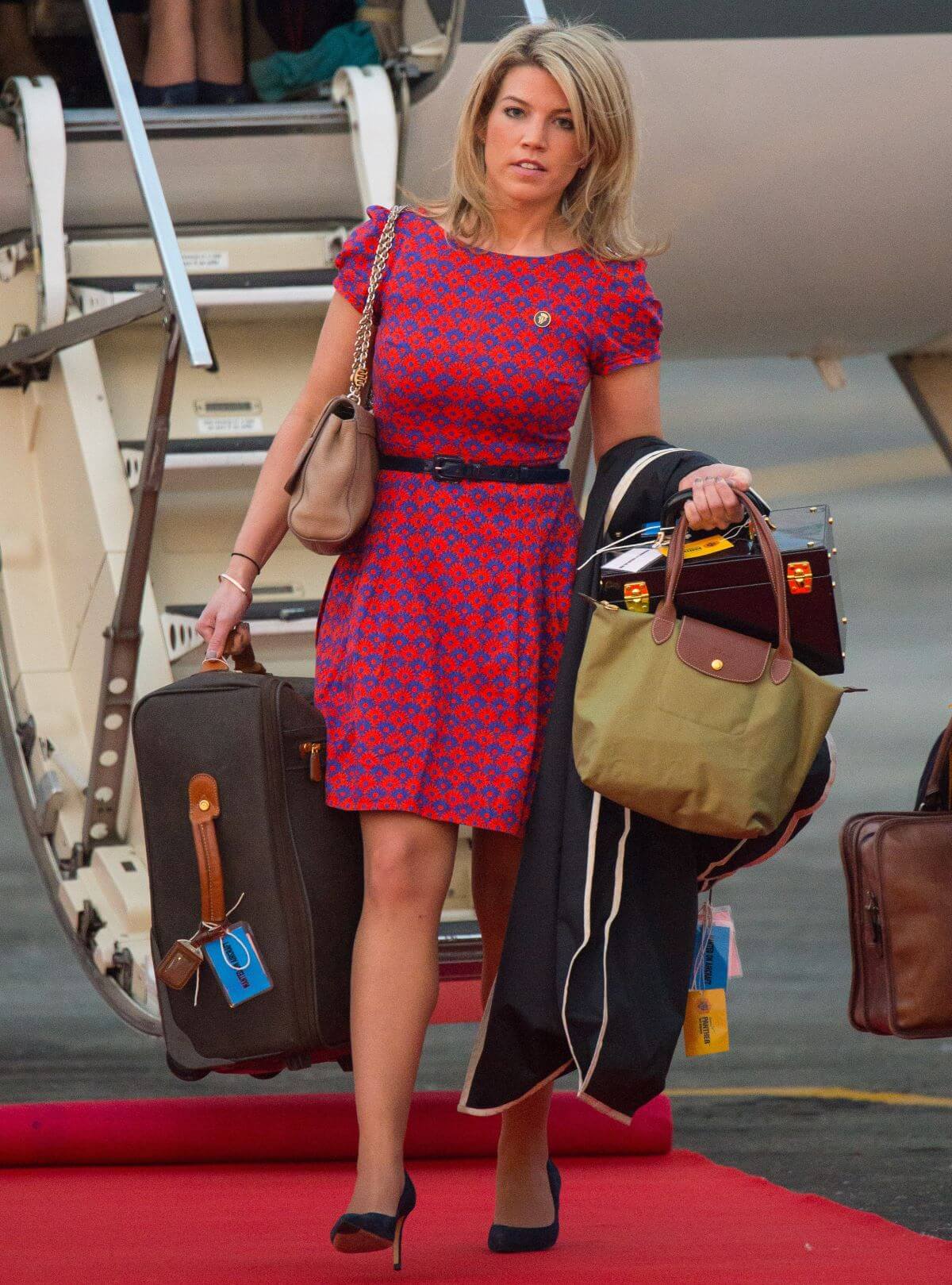 Kate Middleton's assistant and stylist Natasha Archer carries luggage as she arrives at Tezpur Airport in India