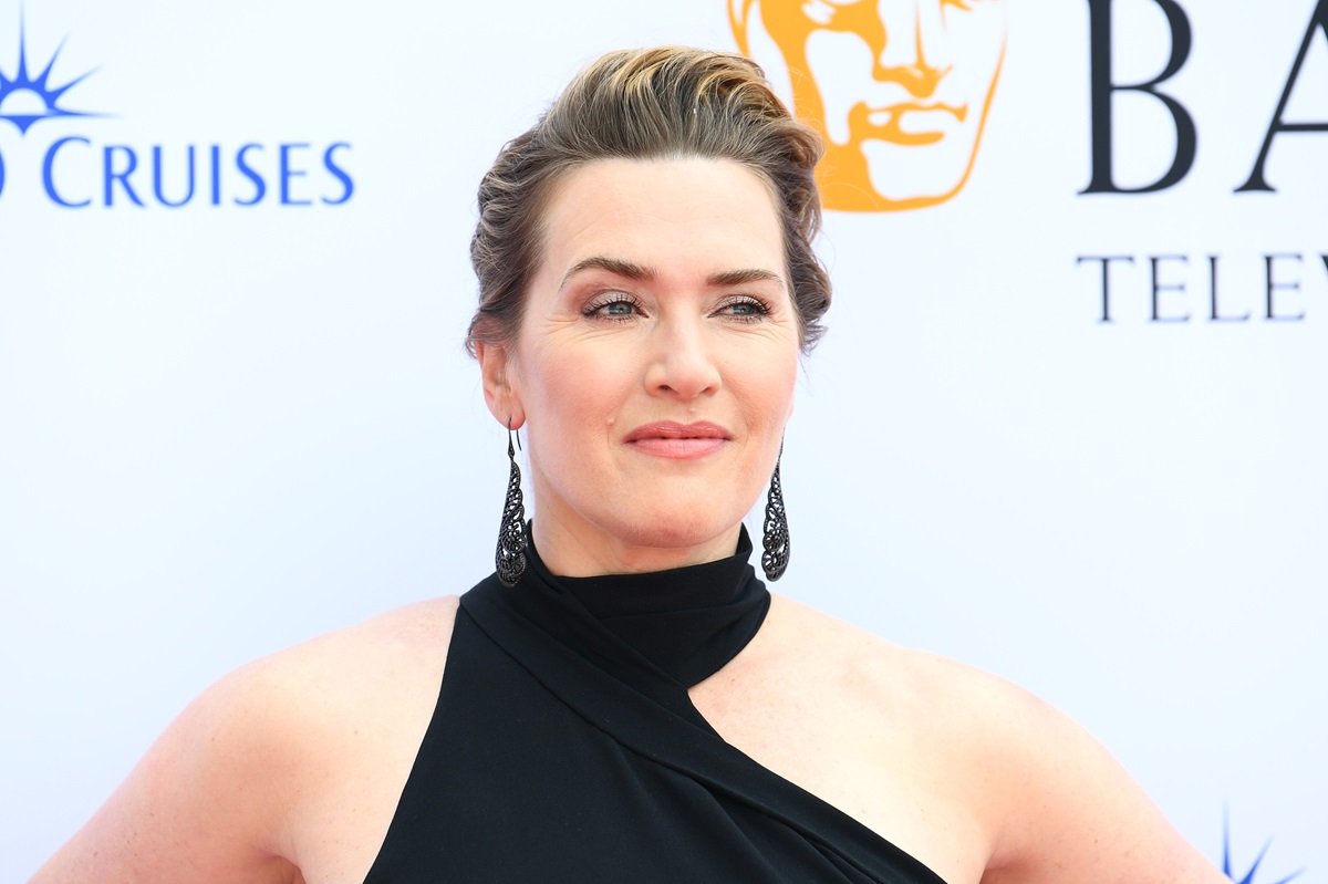 Kate Winslet posing at the BAFTAs while wearing a black dress.