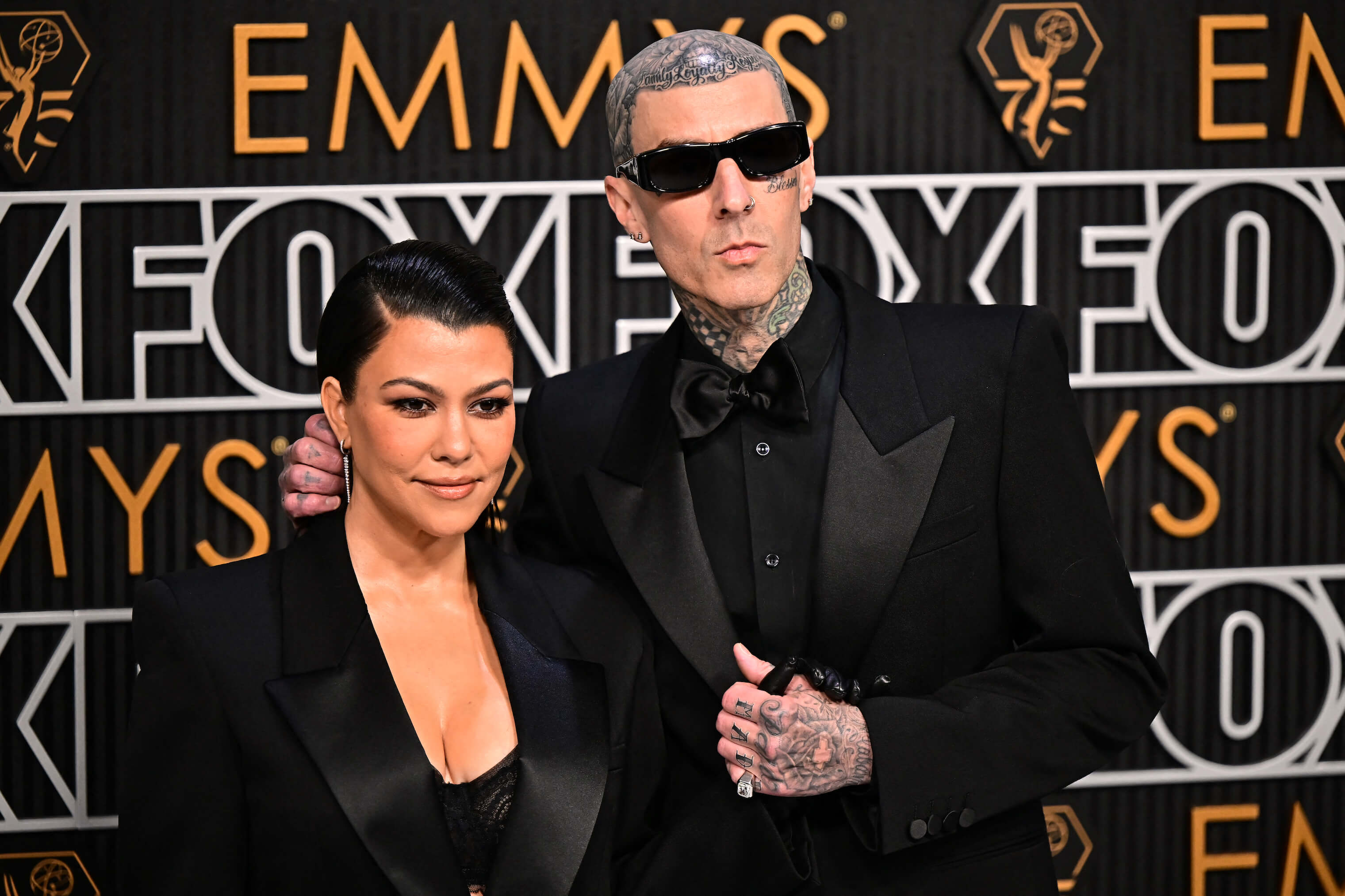 Kourtney Kardashian standing next to Travis Barker at the Emmy's