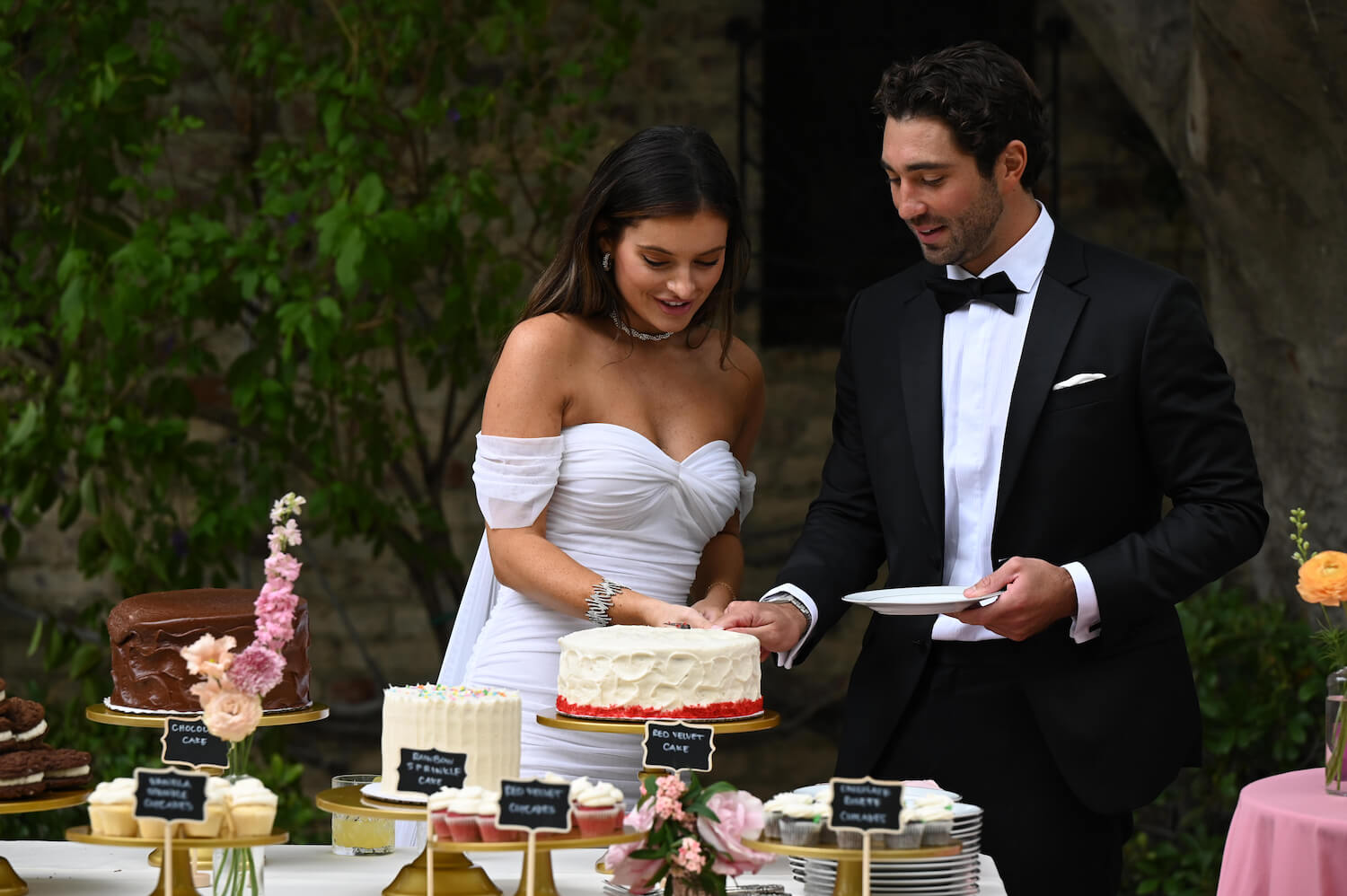 'The Bachelor' Season 28 star Joey Graziadei in a tux, cutting cake with Lexi Young, who's wearing a wedding dress