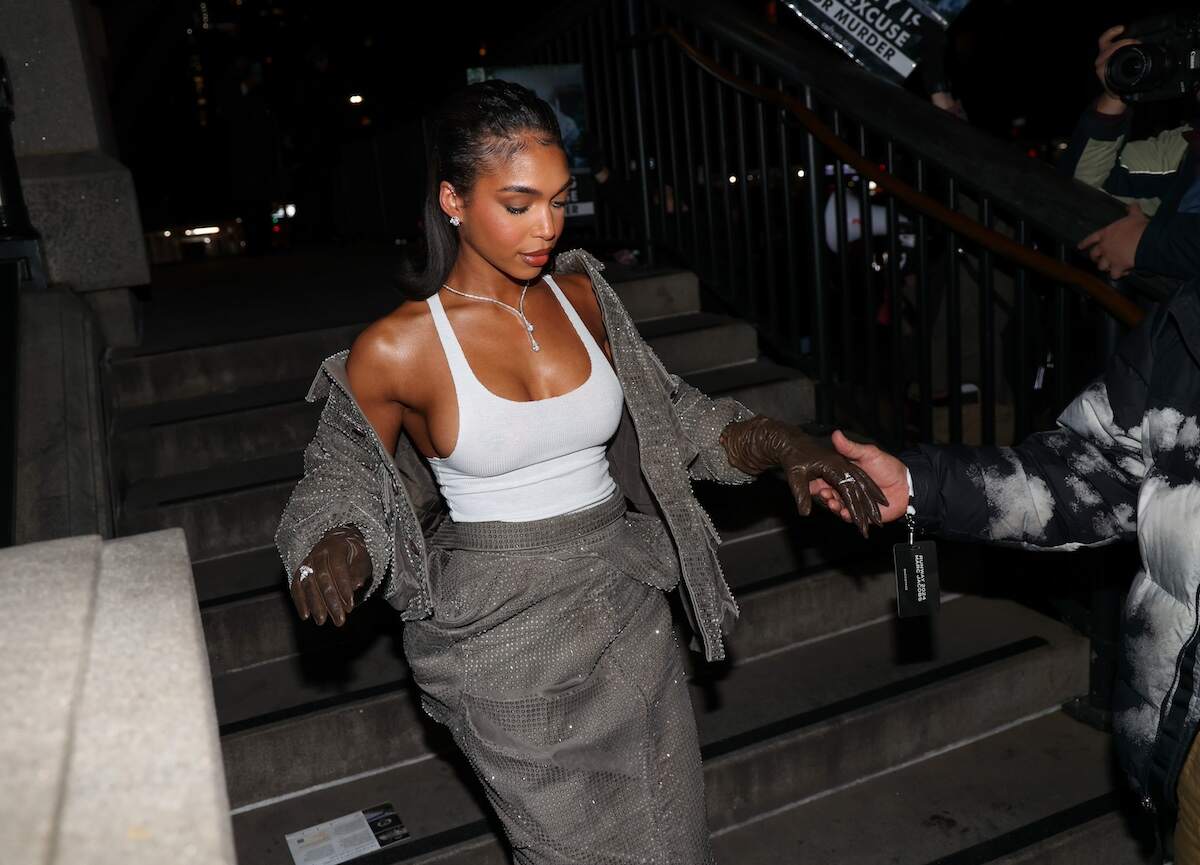 Model Lori Harvey walks down some steps in a gray skirt