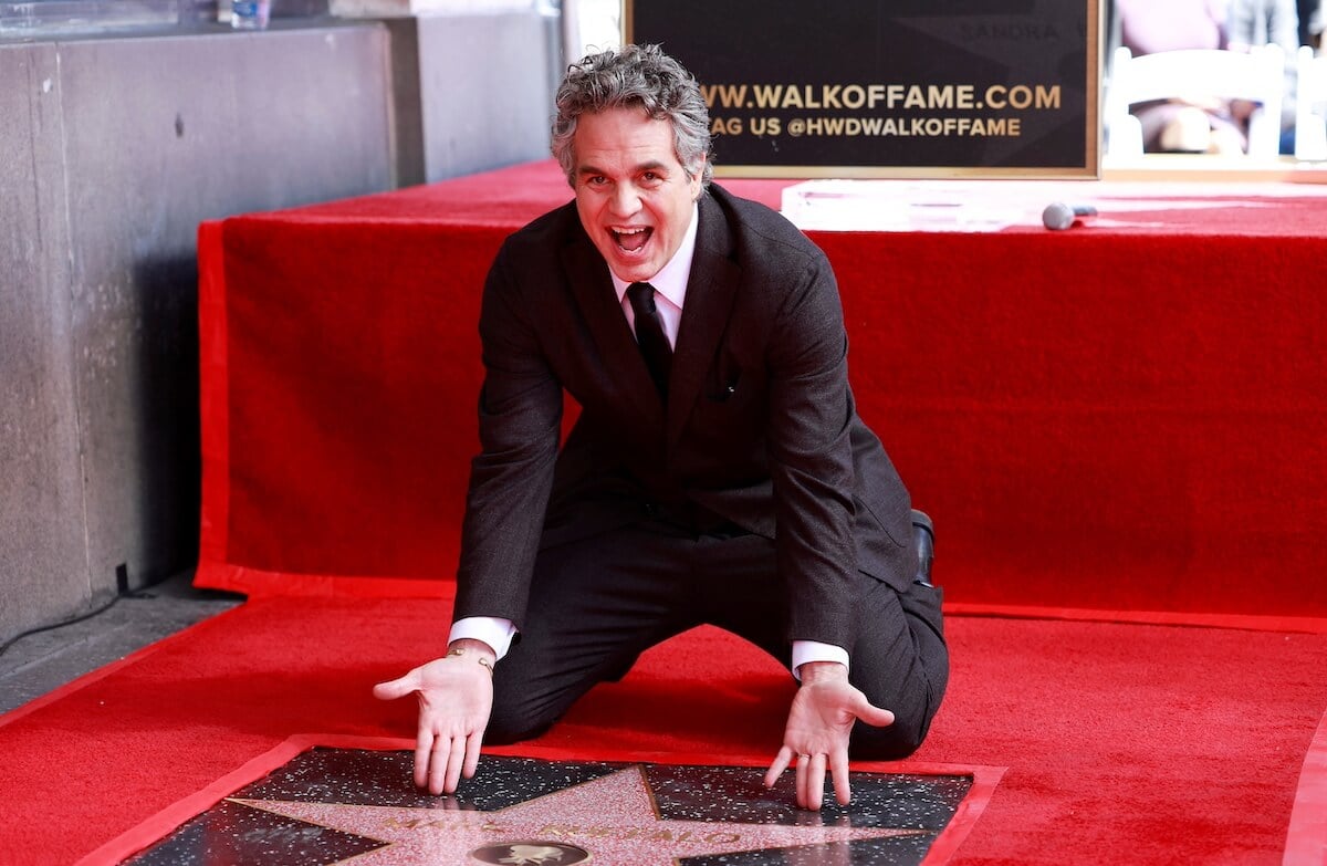 Mark Ruffalo kneeling before his Walk of Fame star