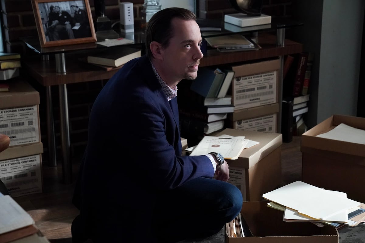 Agent Timothy McGee crouching among file boxes on 'NCIS'