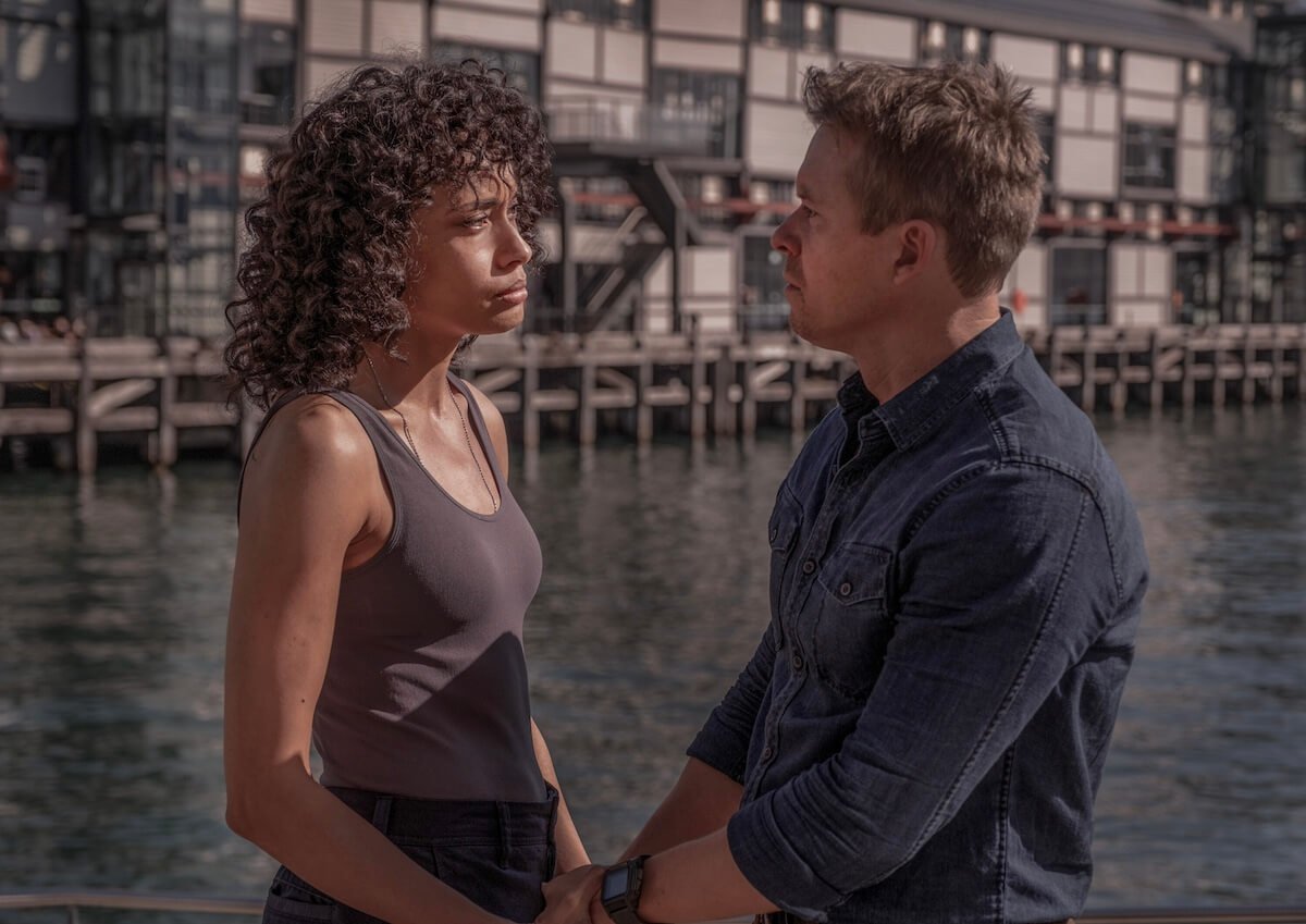 Mackey and Dempsey standing in front of shipping containers and talking in 'NCIS: Sydney'