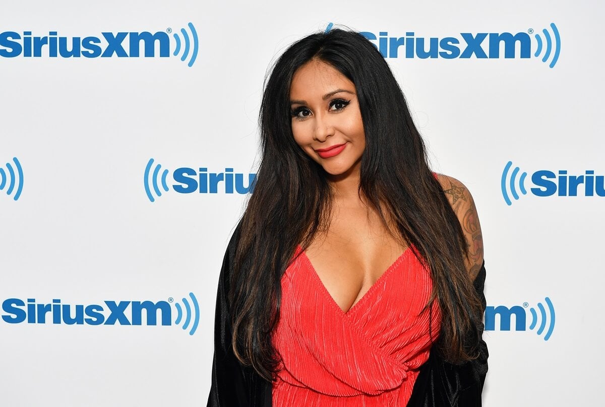 Nicole Polizzi posing at Sirius XM wearing a red shirt.