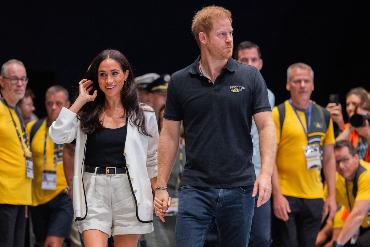 Prince Harry and Meghan Markle hold hands at the 2023 Invictus Games