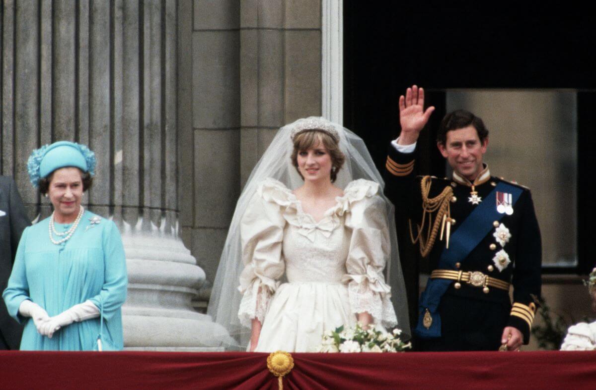 Princess Diana and then-Prince Charles standing on a balcony at Buckingham Palace with Queen Elizabeth II following royal wedding