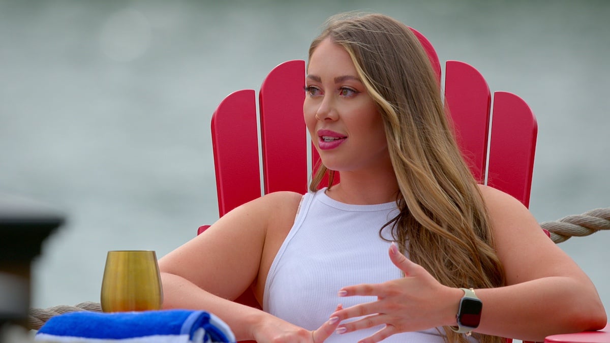 Sarah Ann sitting in an Adirondack chair in front of a lake on 'Love Is Blind' Season 6