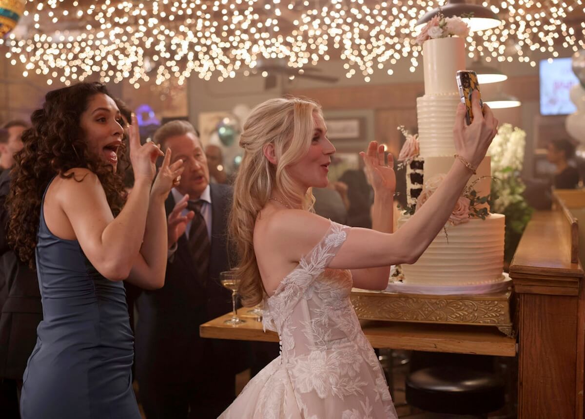 Sylvie Brett, in her wedding dress, taking a selfie in front of a wedding cake in 'Chicago Fire'